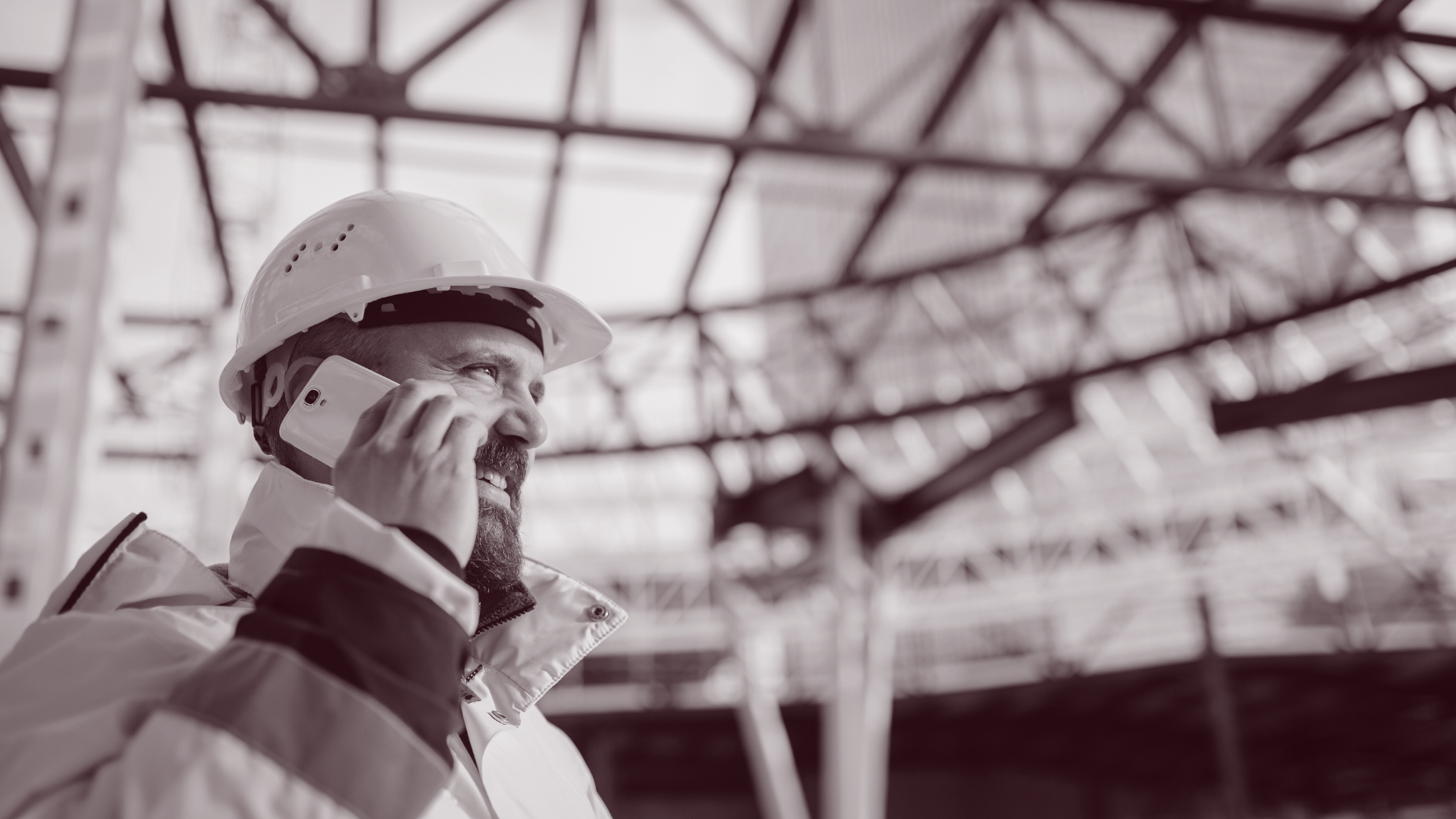 Man pratar i telefon på byggarbetsplats